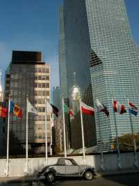 The 2CV inside the United Nations areal with some flags in the background